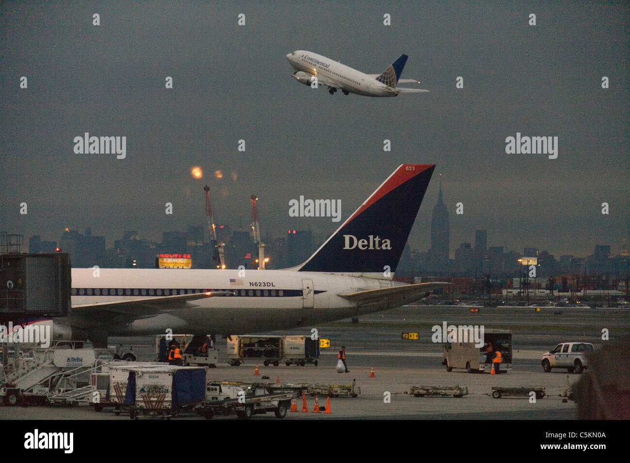 Plane at gate, plane climbing and Empire State Building in distance, NJ Stock Photo