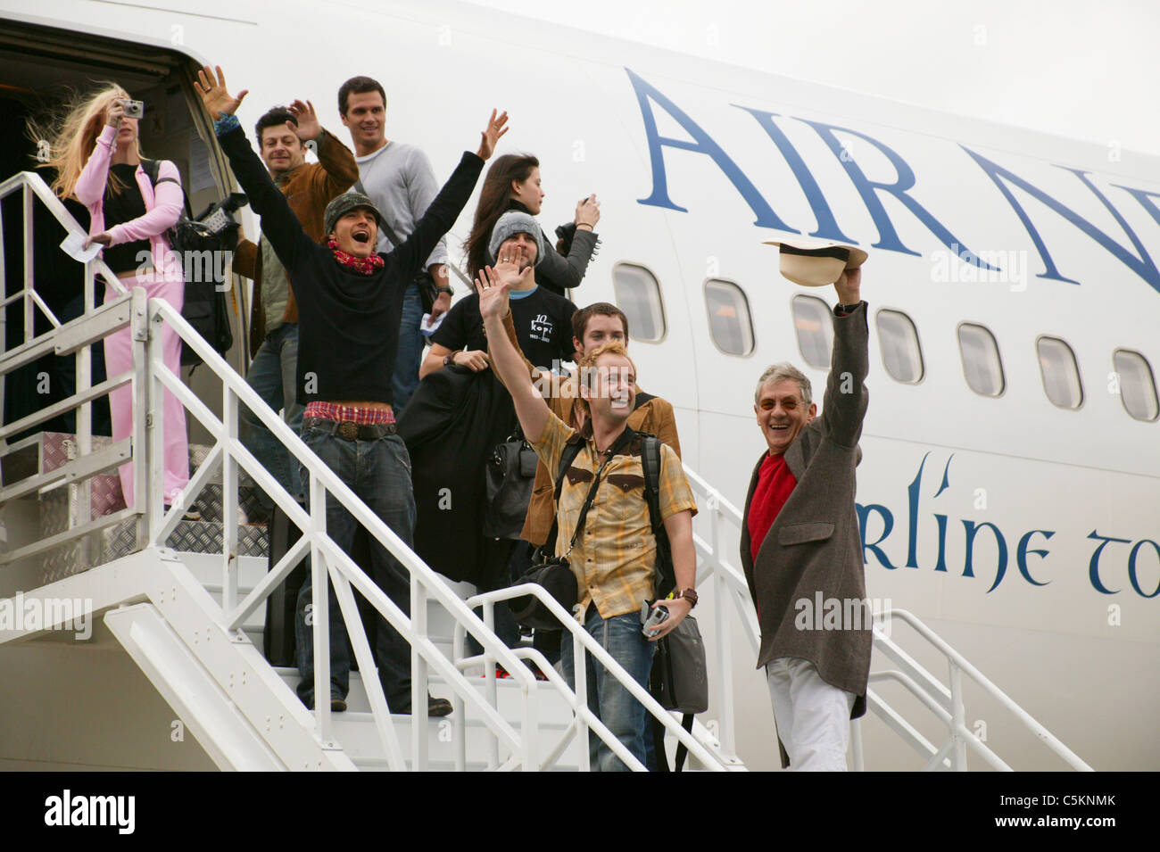 Stars of Lord of the Rings movies waving farewell on steps of Air New Zealand Boeing 767 airliner at Wellington Airport, New Stock Photo