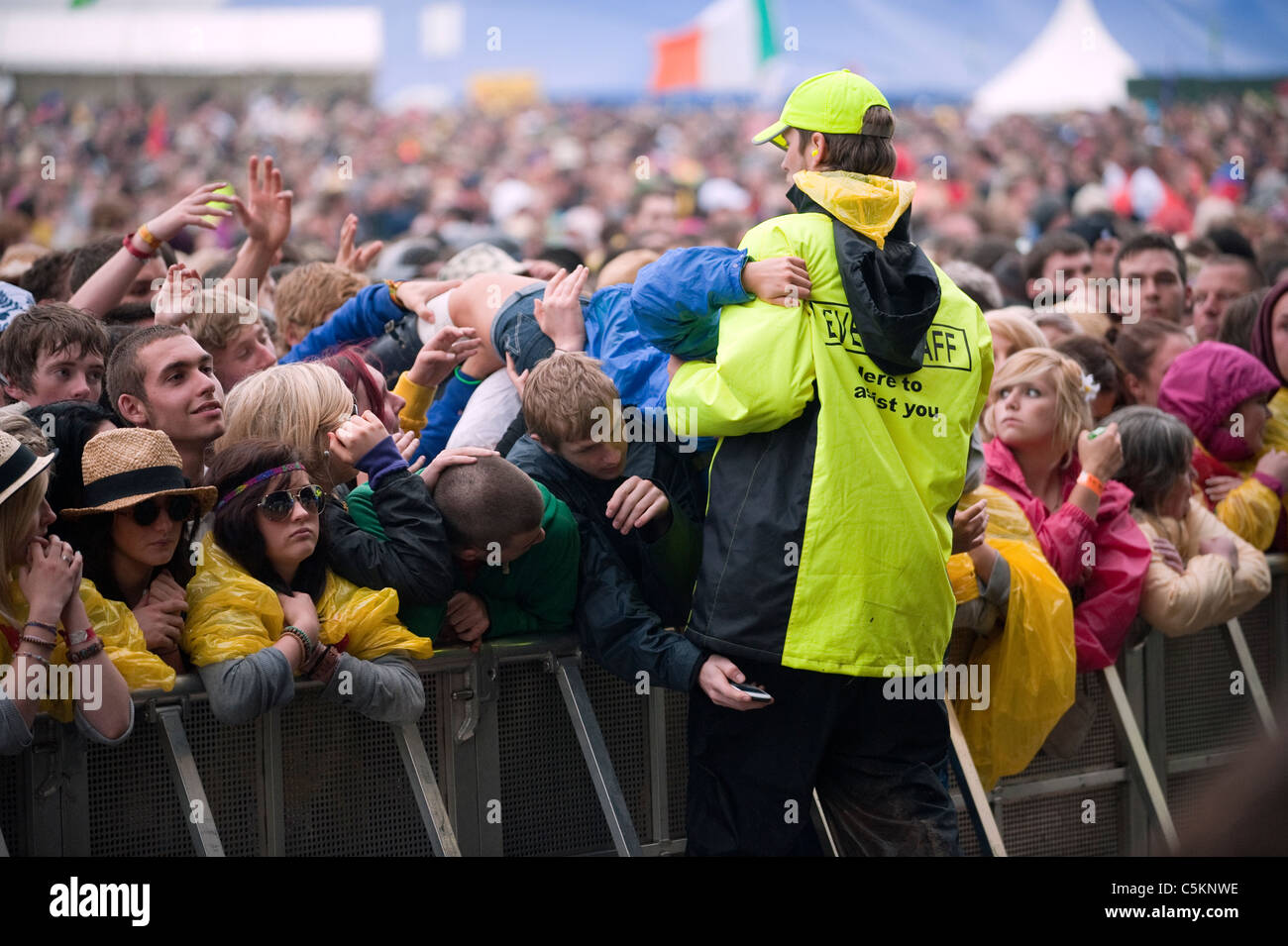 A crowd surfing fan is helped by festival security. Stock Photo