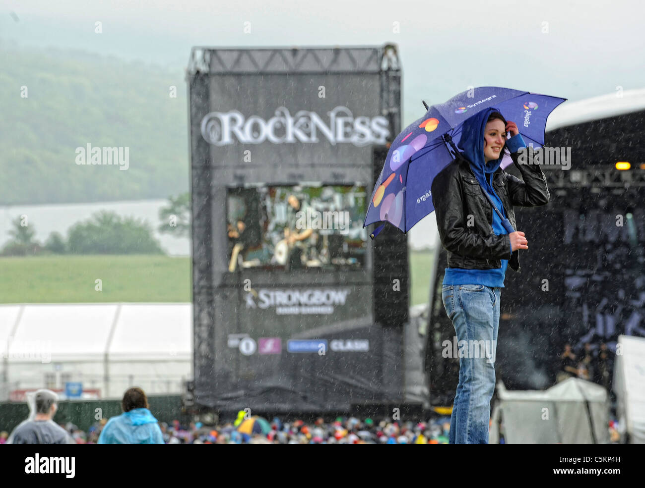 Music fans stands in the rain during the Rockness music festival in