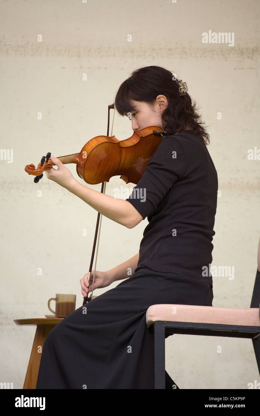 Young Chinese woman playing a violin Stock Photo