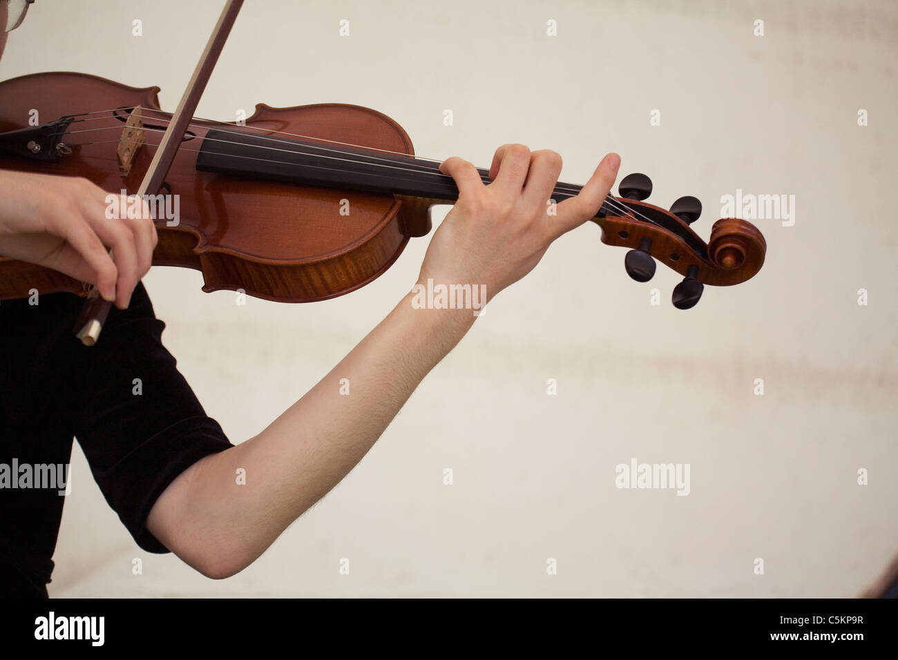 Hands and left arm of young woman playing a violin, close-up Stock Photo