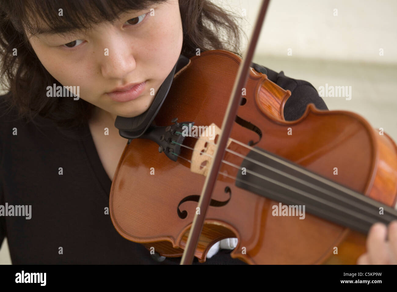 Young Chinese woman playing a violin, close-up Stock Photo