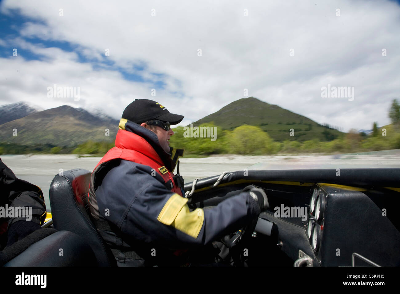 Pilot driving a Jet boat full of tourists at speed on the Kawarau River