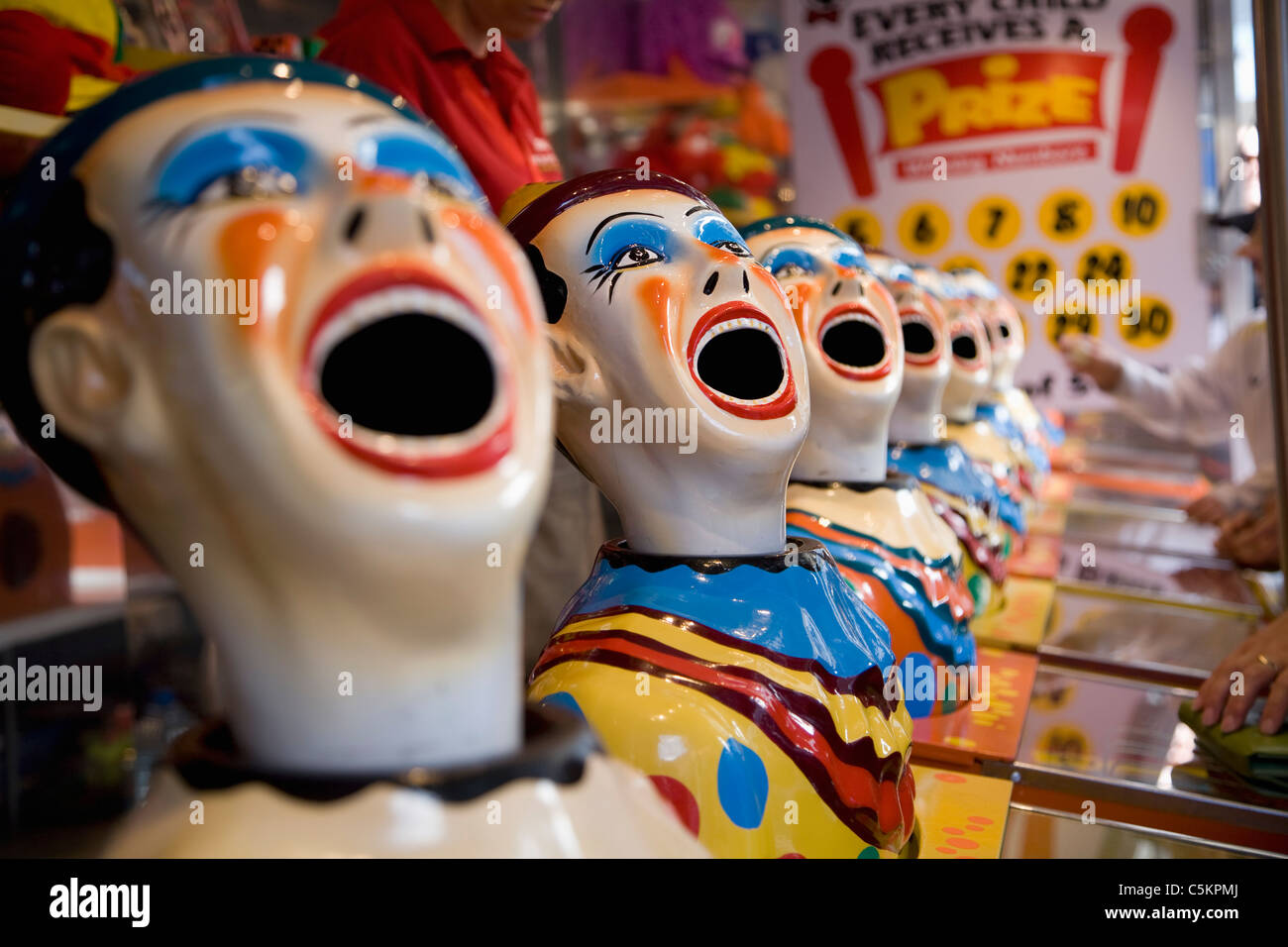 Model heads of clowns with open mouths for a ball game at at stall in a street fair, Cuba Street, Wellington, New Zealand Stock Photo