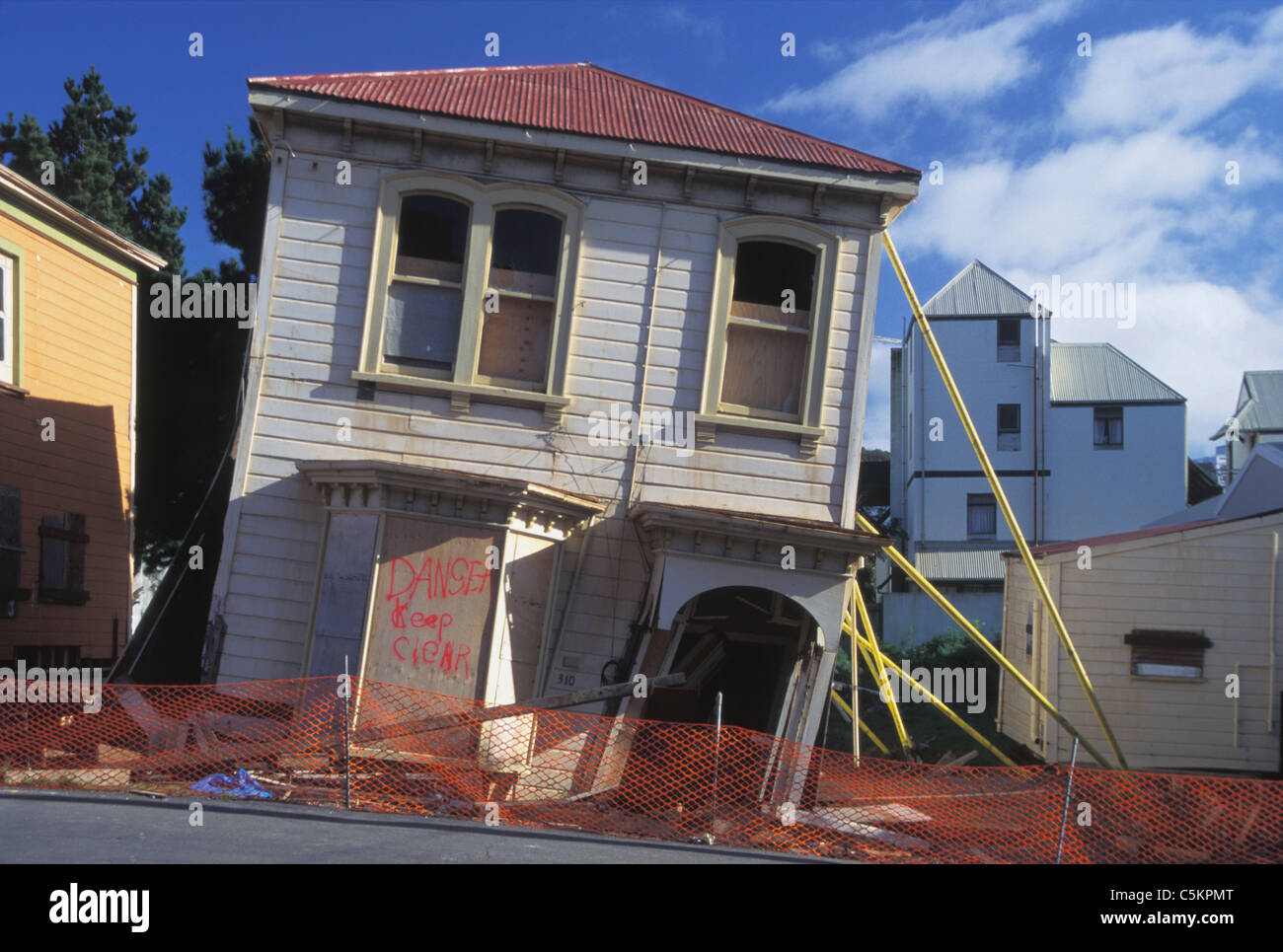 Small damaged timber house, collapsing , propped up to stop it falling over Stock Photo
