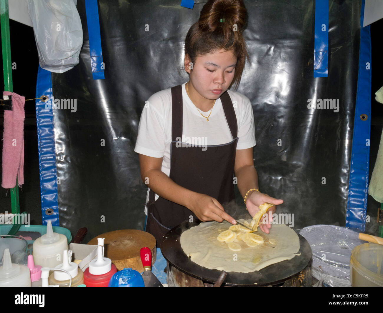 PHUKETT, THAILAND - JUN 9 2011:Roadside food vendor making crepes in Phuket, Thailand on June 9, 2011. Stock Photo