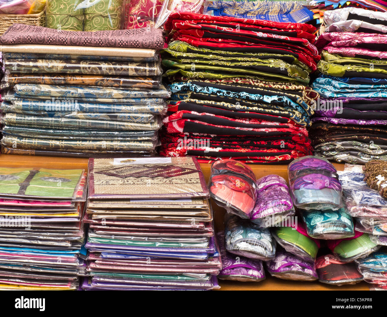 Silk cloth and slippers for sale in market stall Stock Photo
