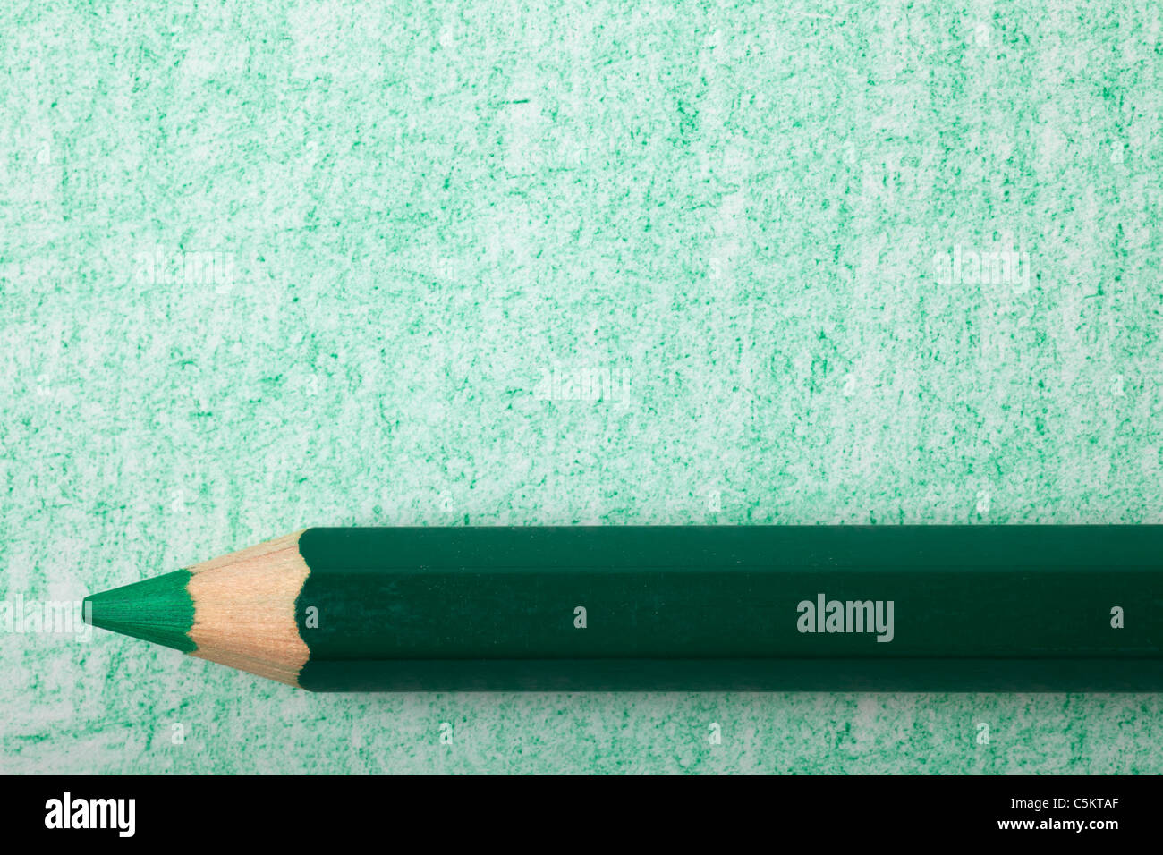 Green color pencil with coloring on a piece of paper Stock Photo