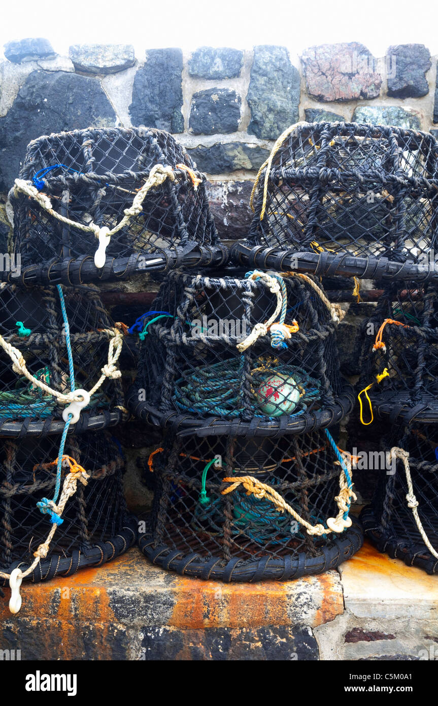 Cornish lobster pots  ( top lit )  in a small fishing harbour.  Cornwall UK. Stock Photo