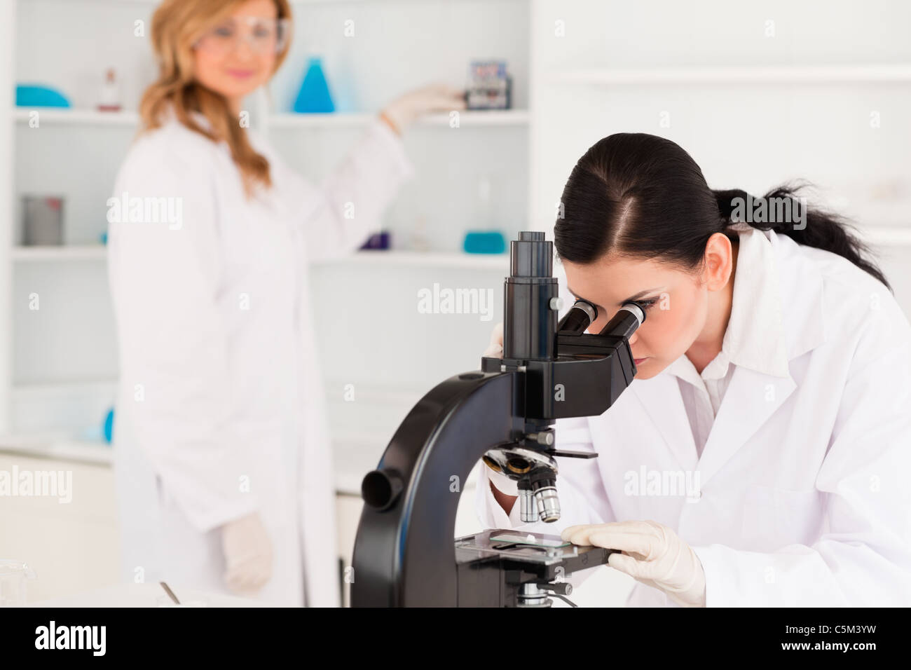 Two scientists working with a microscope Stock Photo