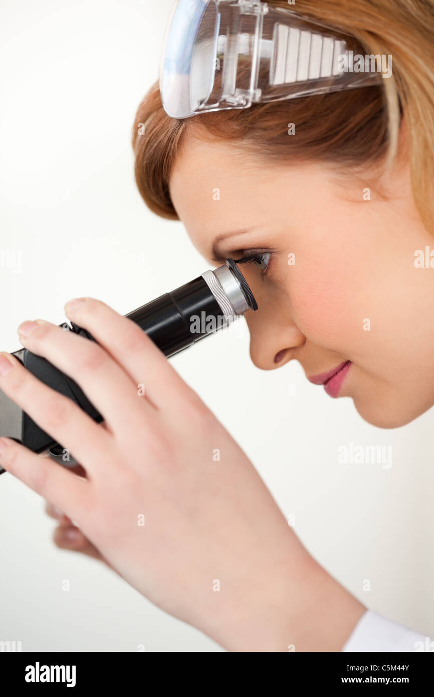 Scientist woman looking through a microscope Stock Photo