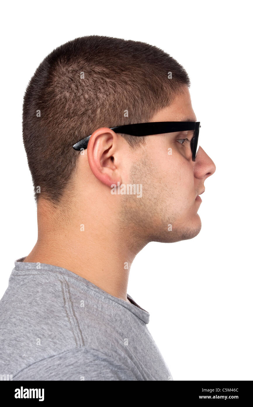 A young teenage man isolated over white wearing black frame nerd glasses and military style dog tags. Stock Photo
