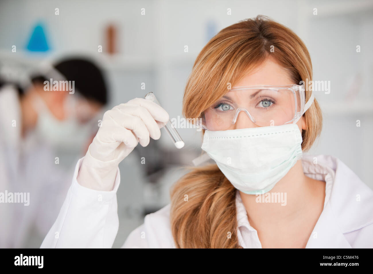 Attractive scientist woman wearing a mask and looking at the camera in a lab Stock Photo