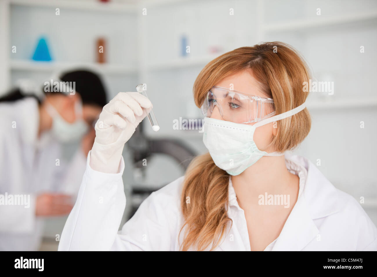 Blond scientist looking at a test tube Stock Photo