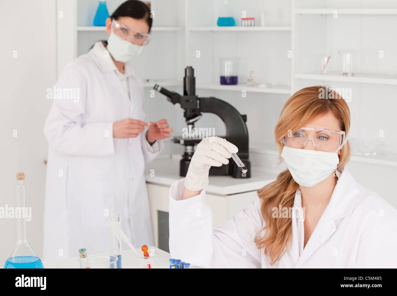 Dark-haired and blond scientists carrying out an experiment Stock Photo