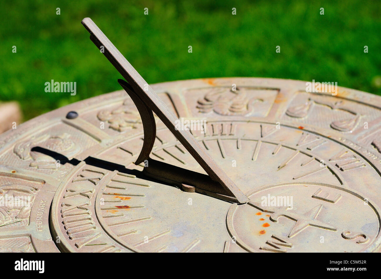 Sundial with Zodiac signs and figures surrounding Roman numeral times