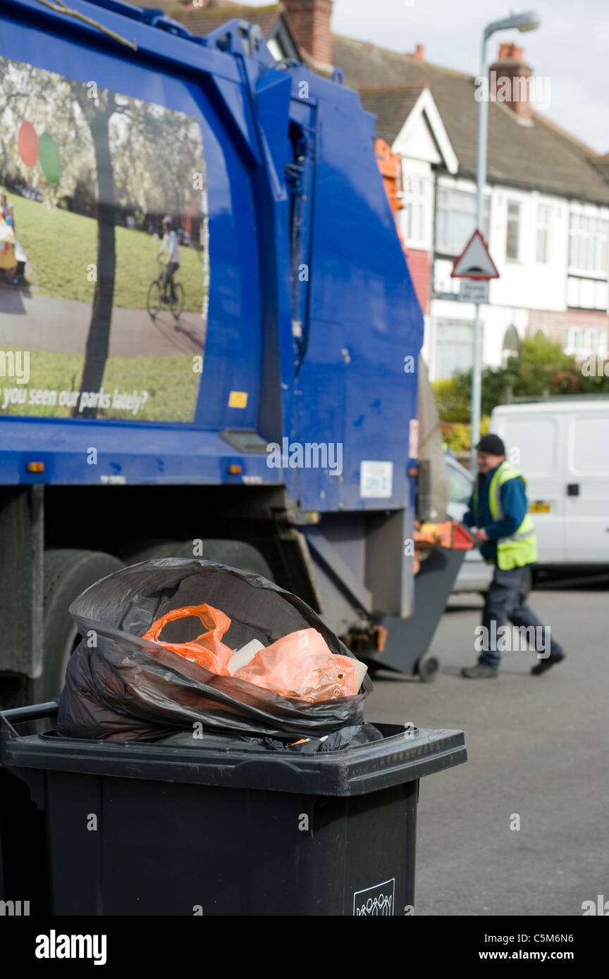 Overflowing wheelie bin waiting for collection by a bin lorry in a
