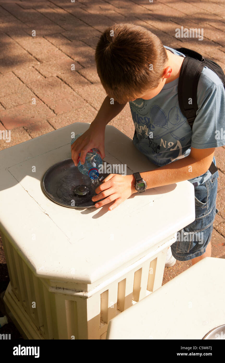 Boy filling water bottle outside hires stock photography and images