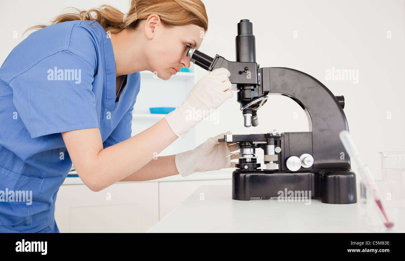 Female scientist looking through a microscope Stock Photo