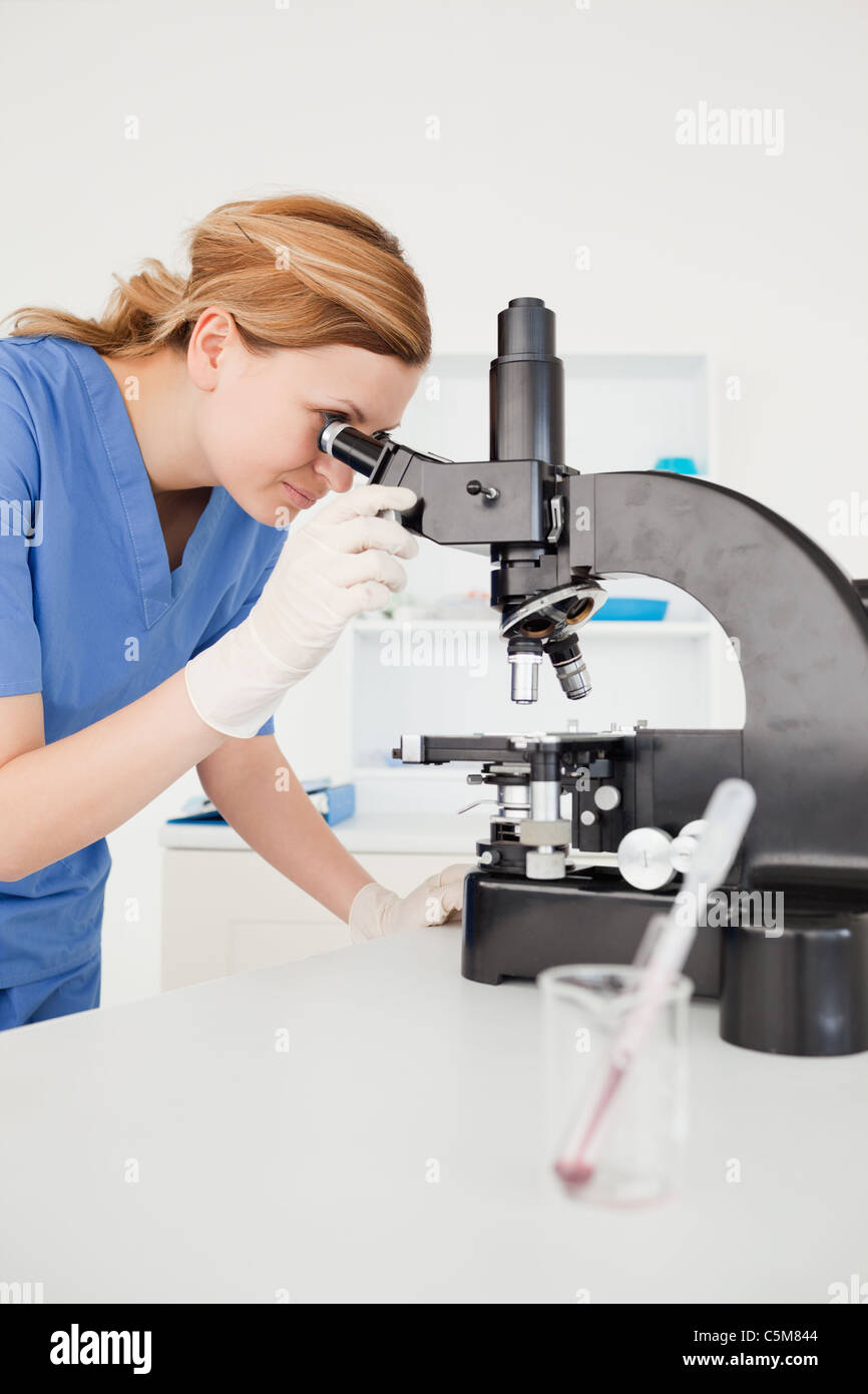 Cute female scientist looking through a microscope Stock Photo
