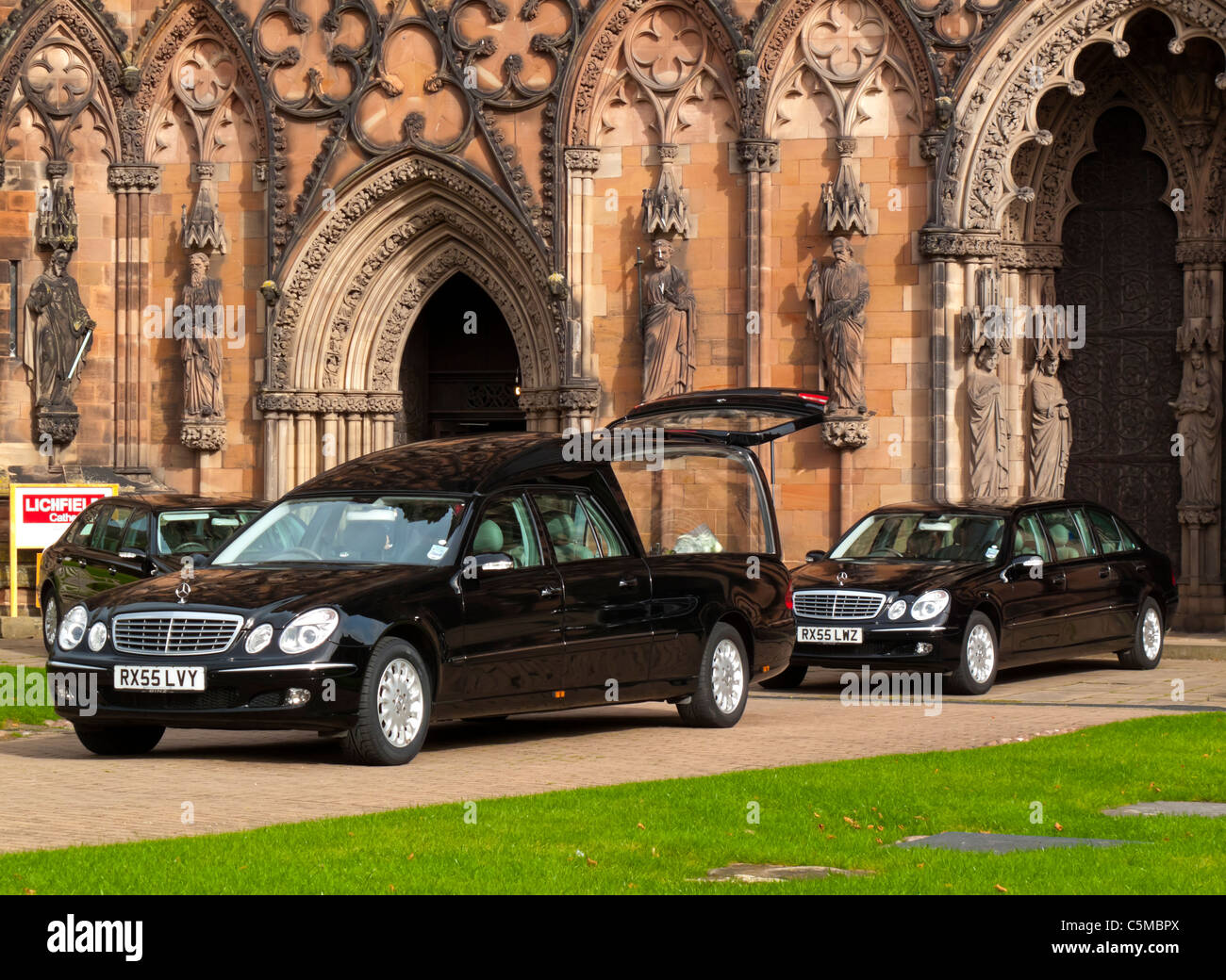 Funeral hearse and stretched Mercedes limousines parked outside Lichfield Cathedral in Staffordshire England UK Stock Photo