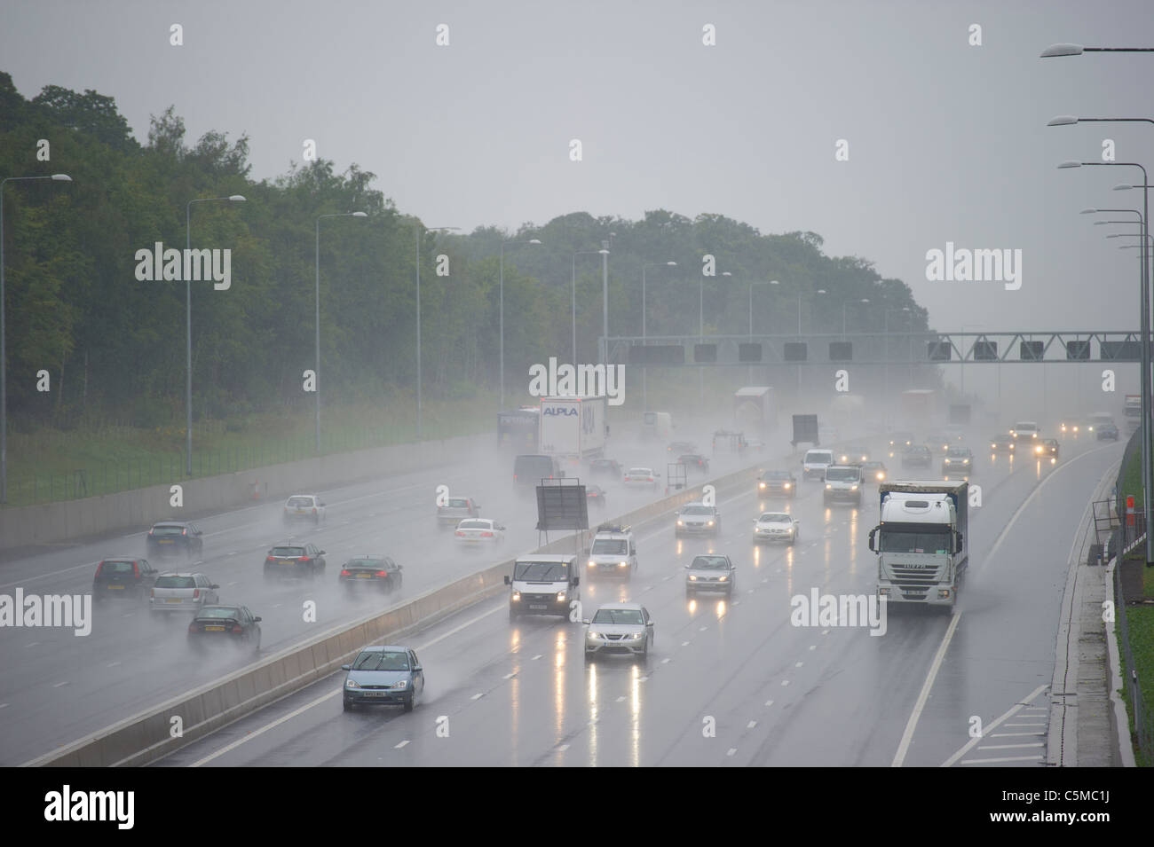 Traffic on the M25 in Essex during heavy rain causing spray and reduced visibility. Stock Photo