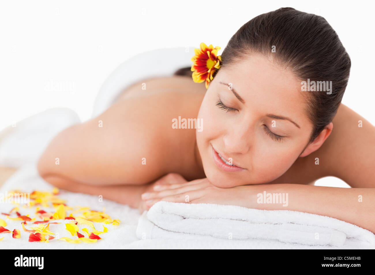 Dark-haired woman closing her eyes and a flower on her ear Stock Photo ...
