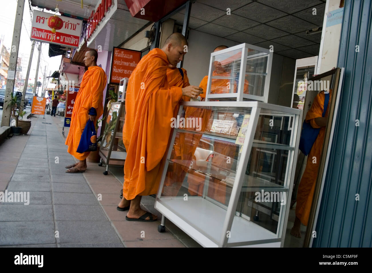 Buddhist monks are shopping at a store in a city in Thailand Stock