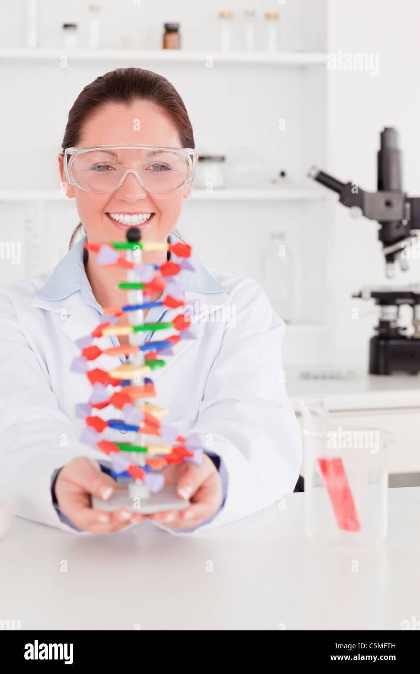 Portrait of a smiling scientist showing the dna double helix model Stock Photo