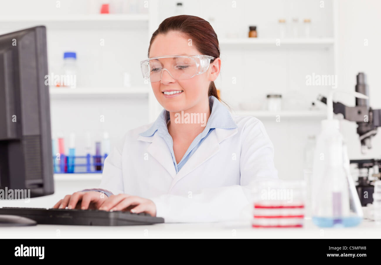 Beautiful scientist typing a report with her computer Stock Photo