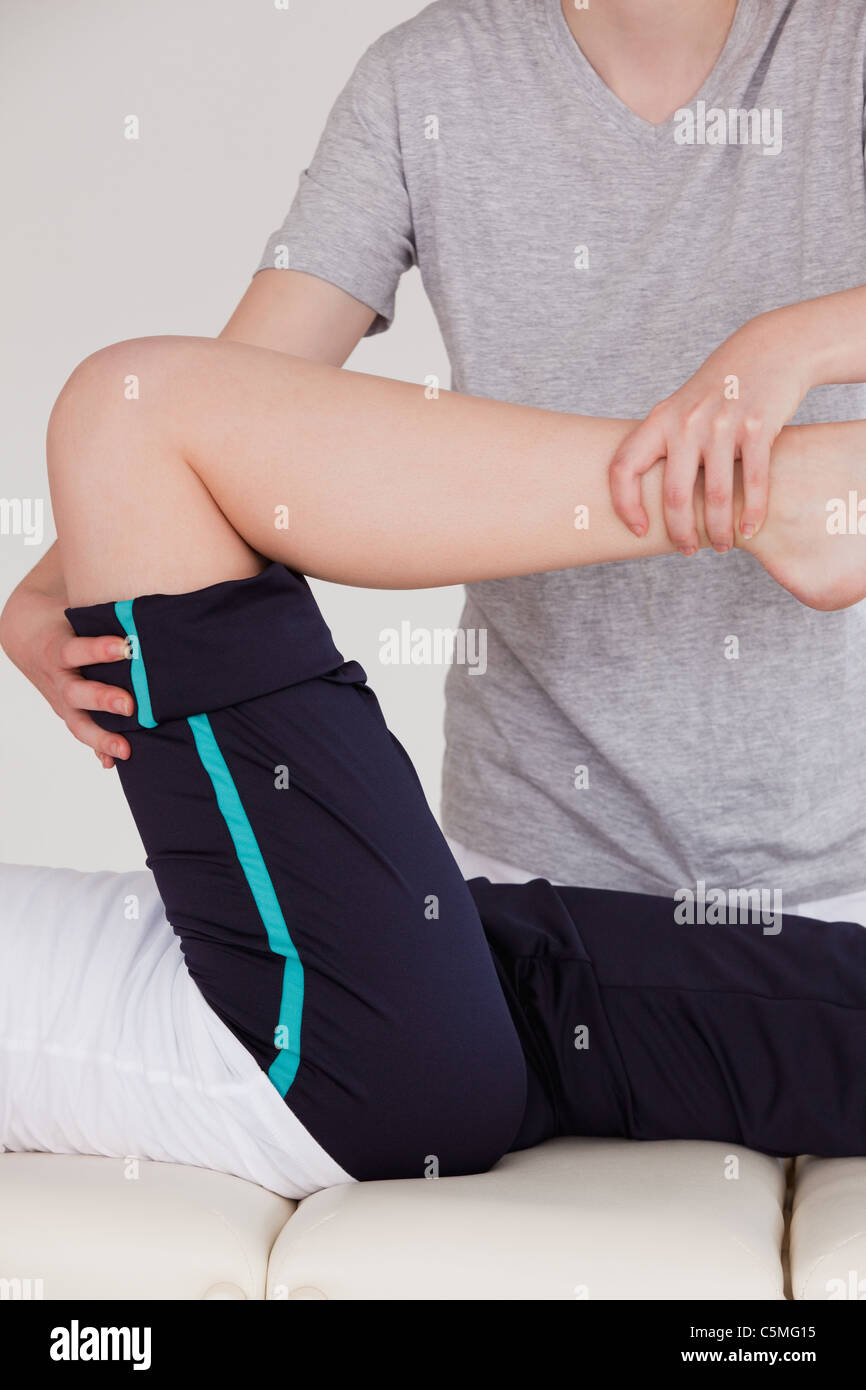 Portrait of a masseuse stretching the right leg Stock Photo