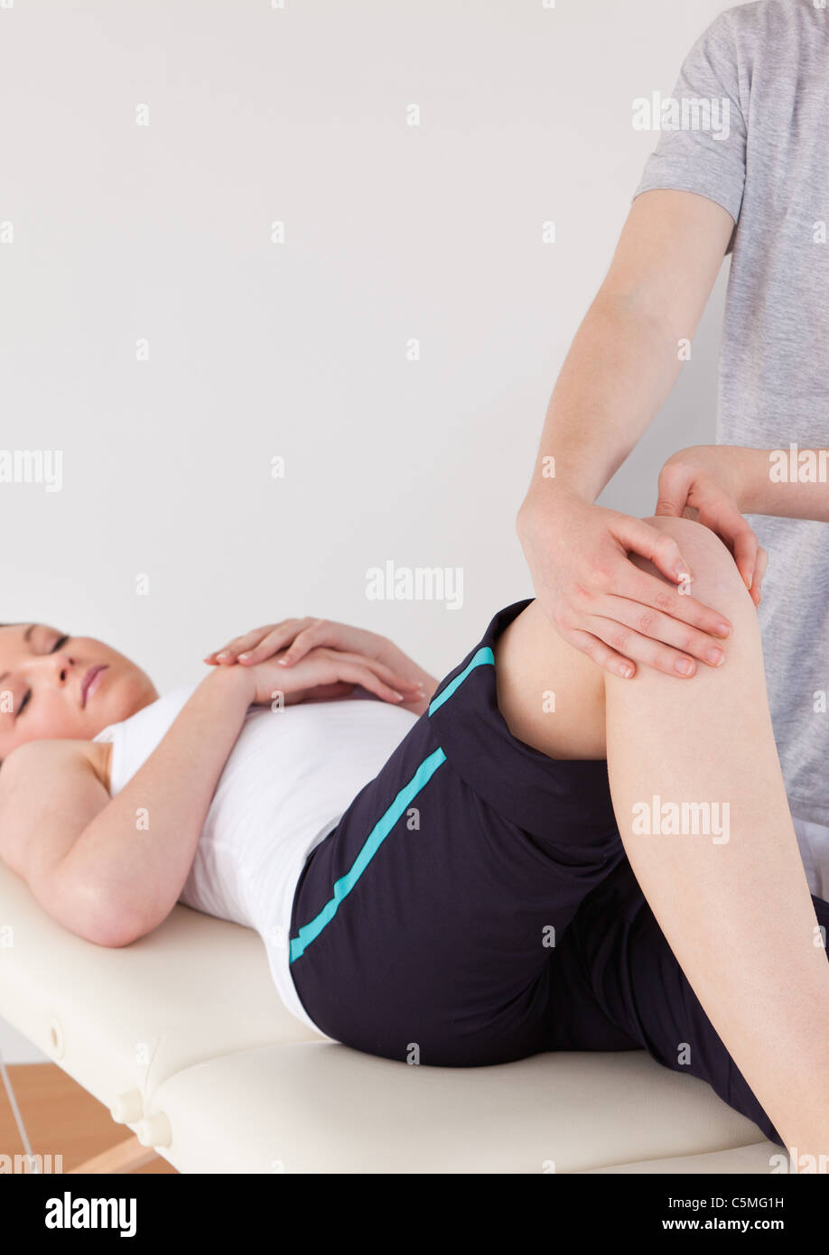 Portrait of a masseuse massing the knee Stock Photo