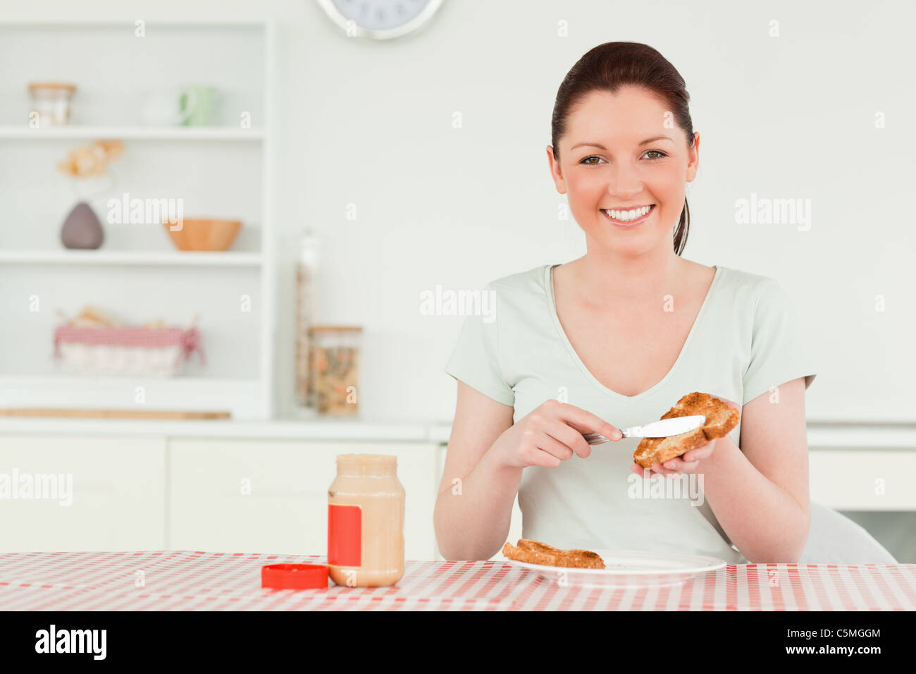 Beautiful woman preparing a slice of bread and marmalade Stock Photo