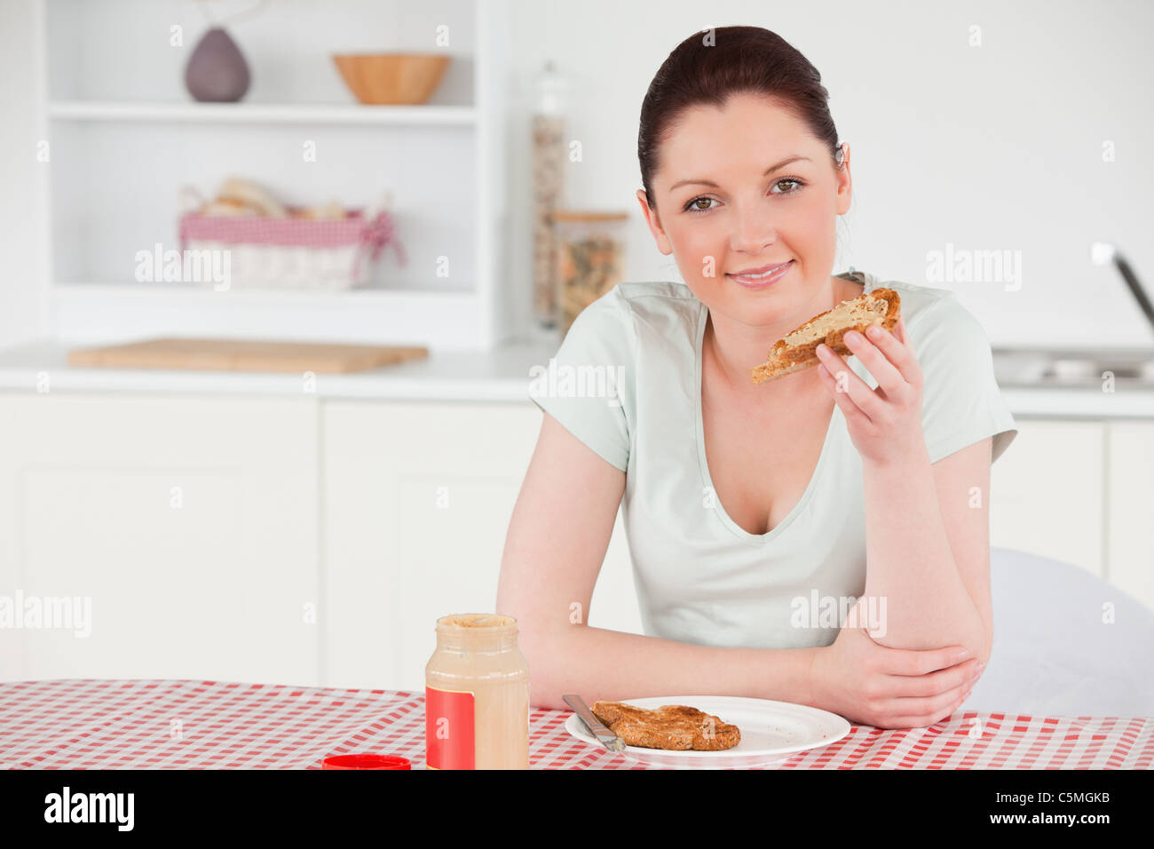 Beautiful woman posing while eating a slice of bread Stock Photo