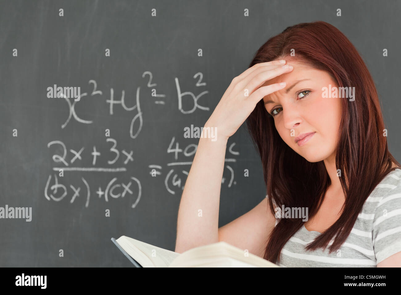 Thoughtful woman trying to solve an equation Stock Photo