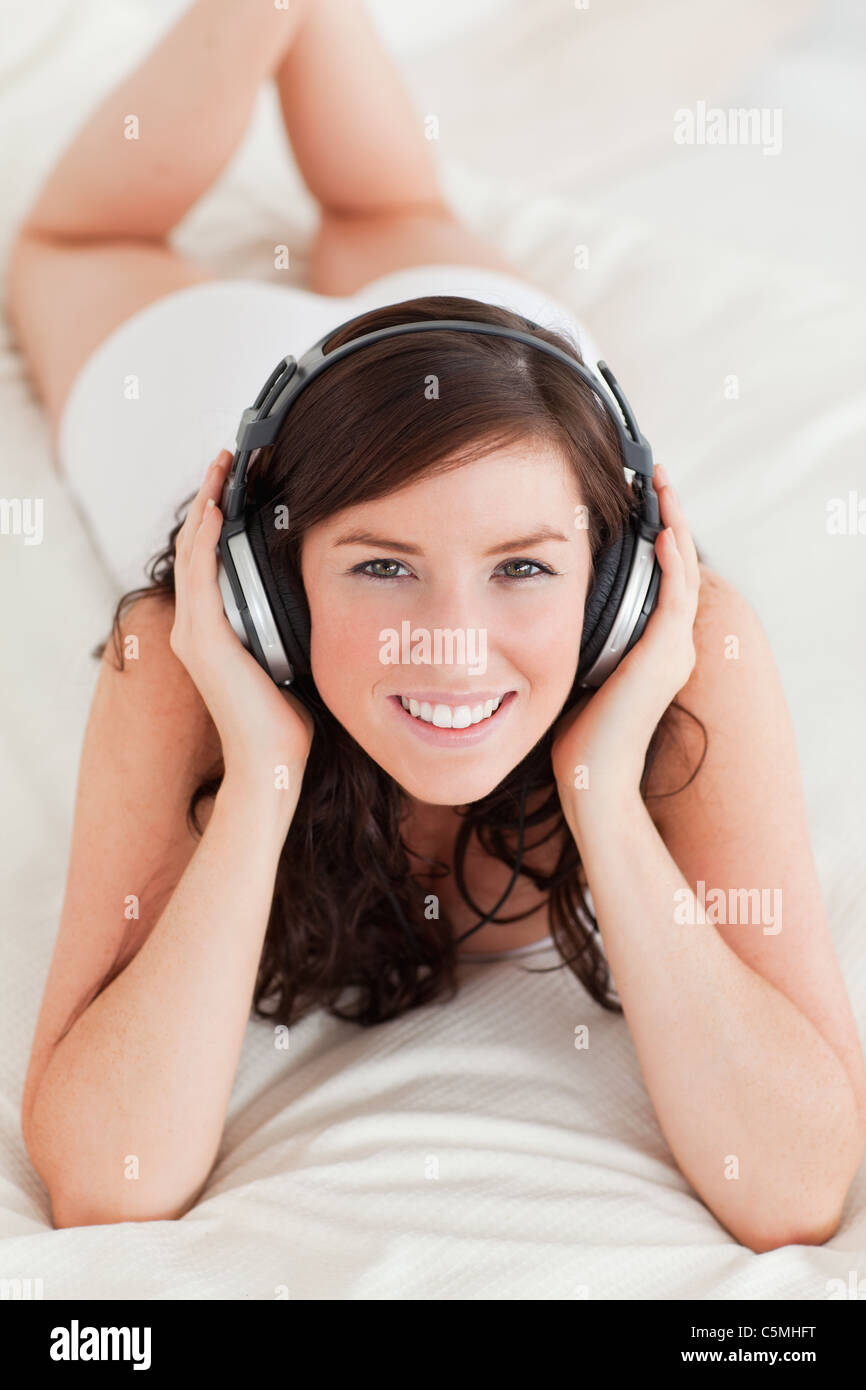 Good looking female with headphones lying Stock Photo Alamy