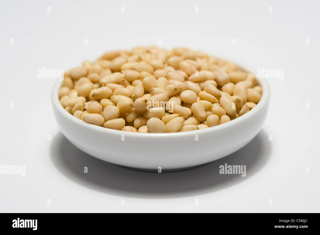 pine nuts in a white bowl Stock Photo