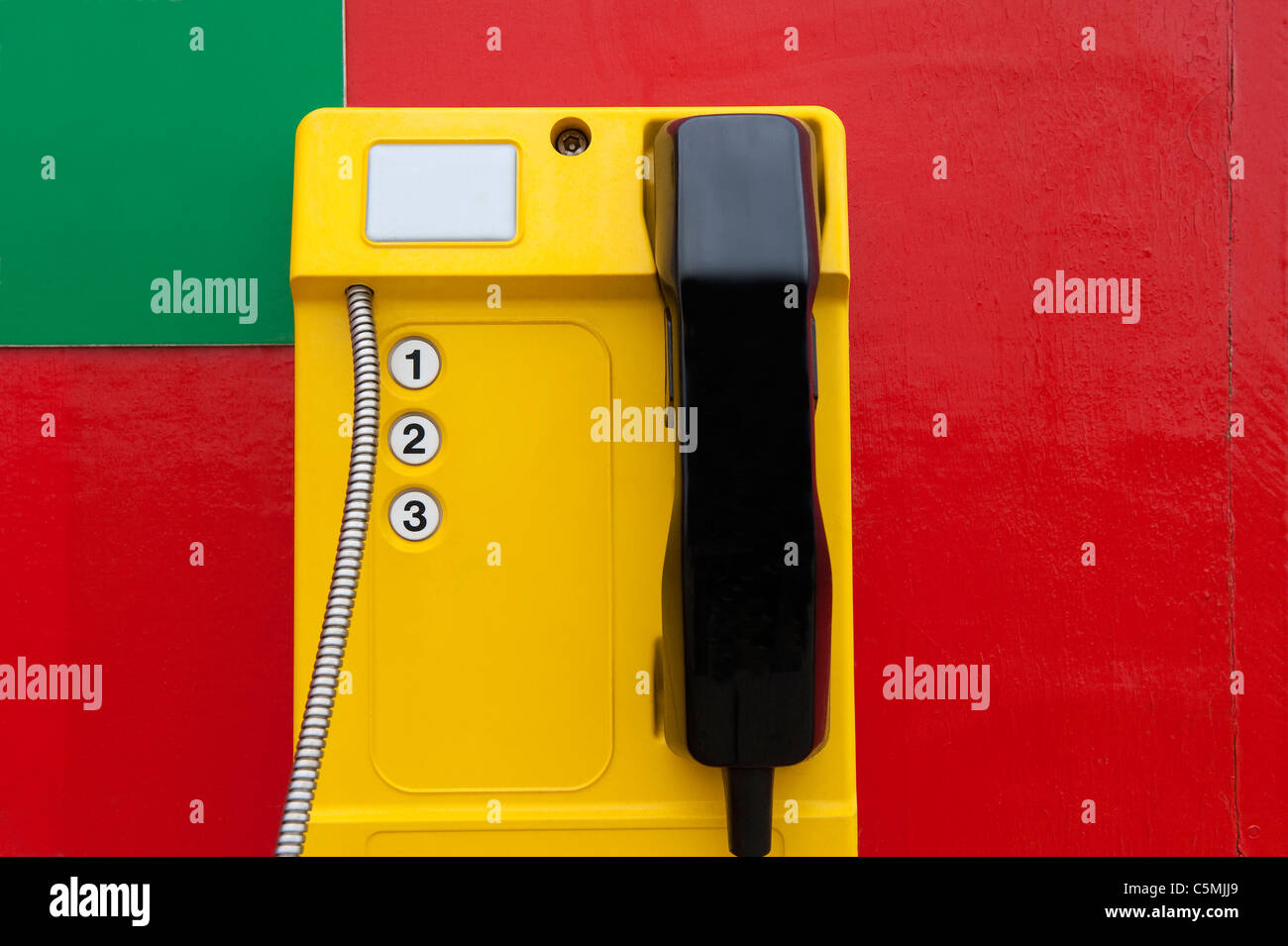 yellow emergency telephone on red board Stock Photo