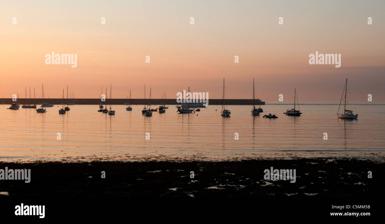 Boats in Braye Bay, Alderney, Channel Islands, at sunset Stock Photo