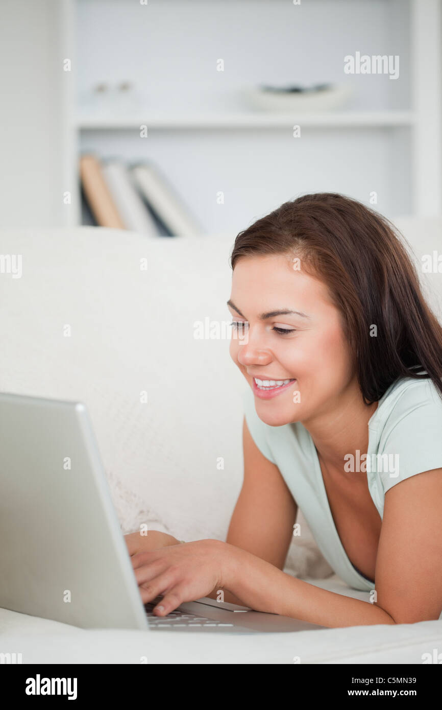 Portrait of a young woman on a sofa using a laptop Stock Photo - Alamy