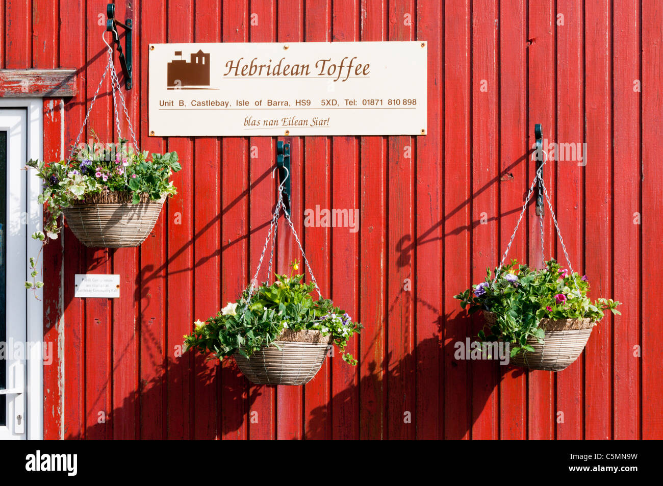 Hanging baskets outside the Hebridean Toffee Shop in Castlebay on the Isle of Barra in the Outer Hebrides Stock Photo