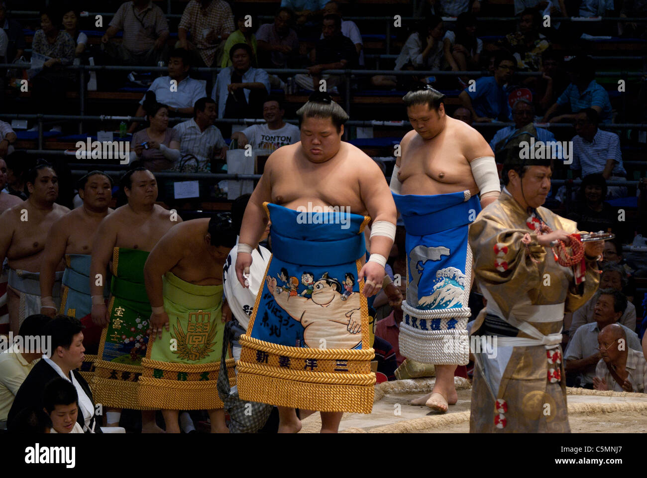 Sumo wrestlers wearing their sponsors garb during the ring entering