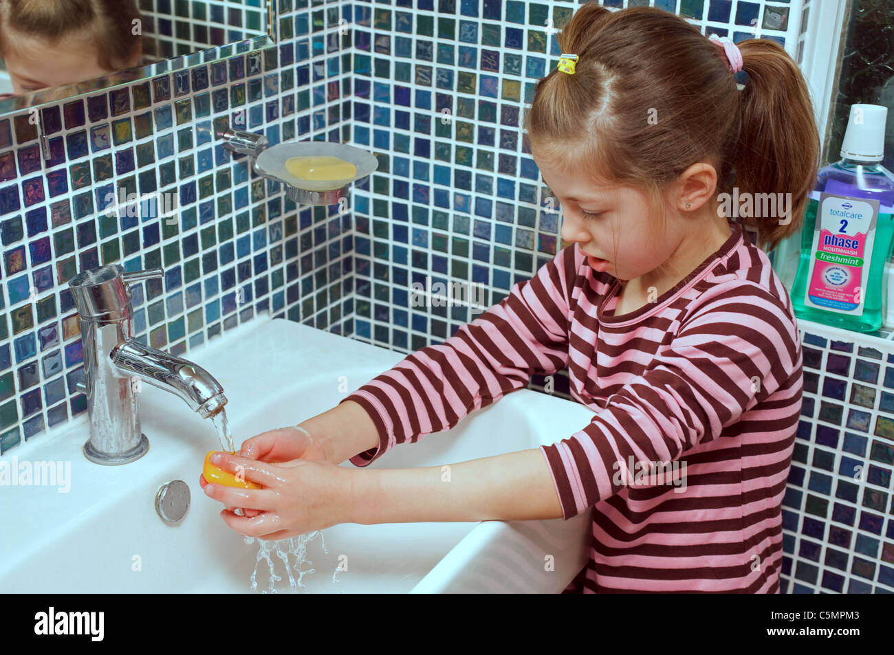 Young girl washing her hands in bathroom sink Stock Photo - Alamy