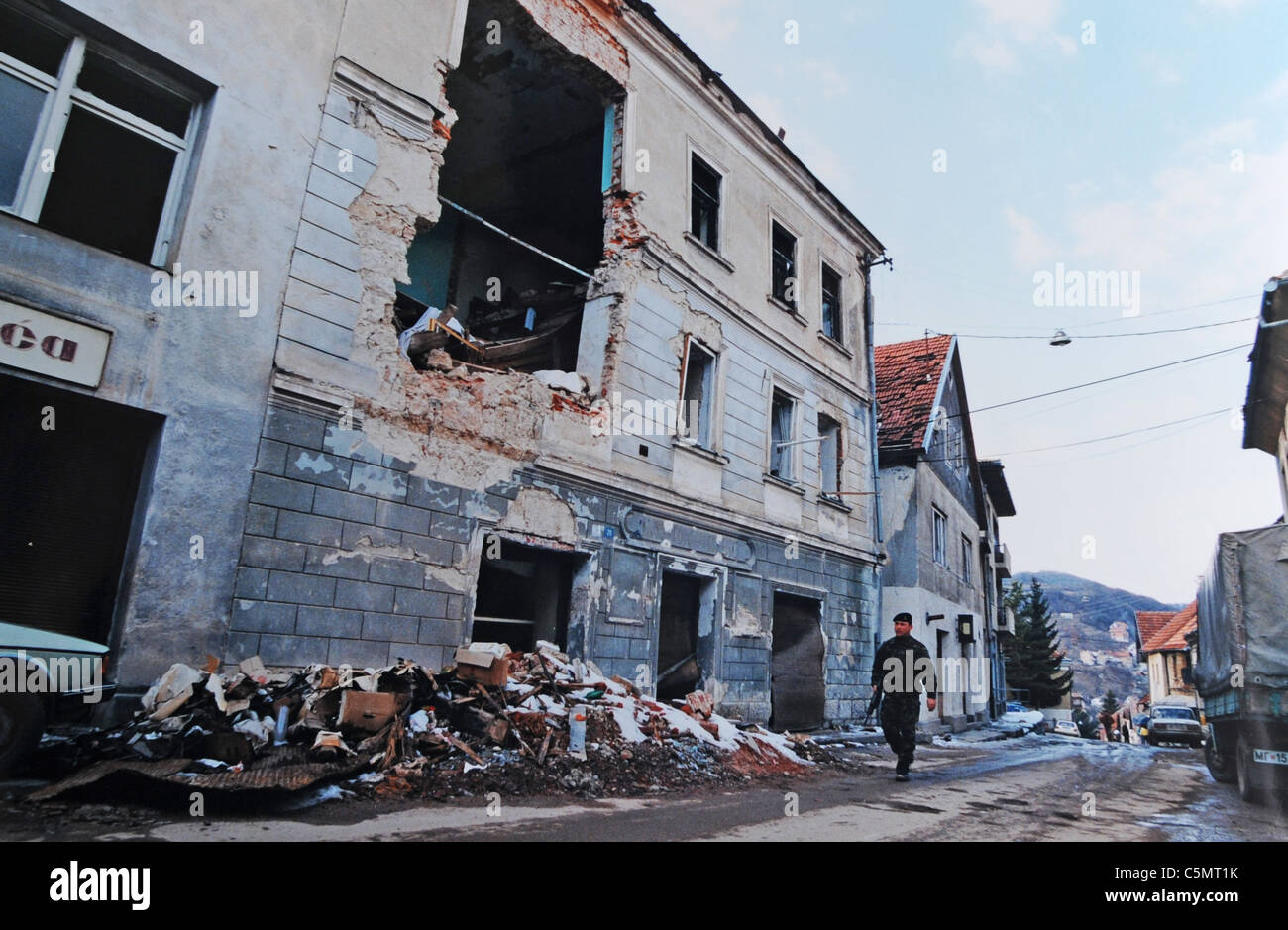 A British soldier from the Sussex Gunners regiment peacekeeping force walks down a completely destroyed street in Mrkonjic Grad  Bosnia - The Bosnian War was an international armed conflict that took place in Bosnia and Herzegovina between 1992 and 1995. Following a number of violent incidents in early 1992, the war is commonly viewed as having started on 6 April 1992. The war ended on 14 December 1995. - Photograph by Simon Dack 1996 Stock Photo