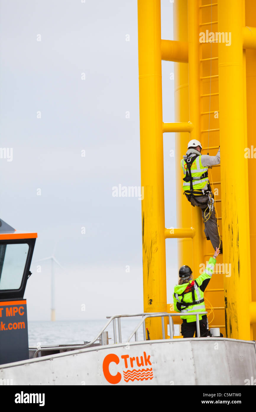 Offshore workers working on a wind turbine at the Walney Offshore windfarm project, off Barrow in Furness, Cumbria, Stock Photo