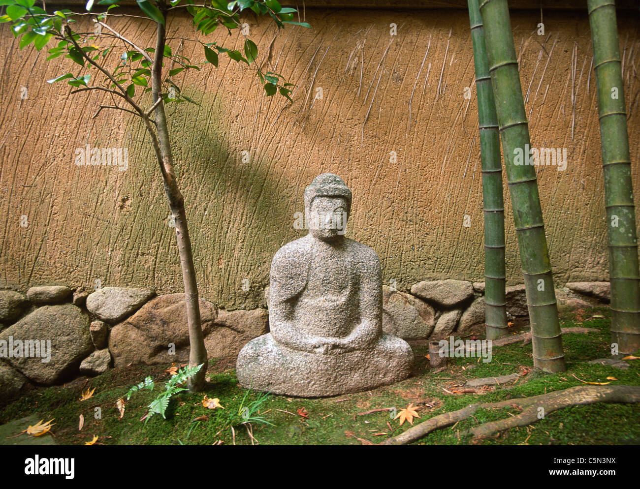 Buddha sculpture and wall in residential neighborhood, Kyoto, Japan