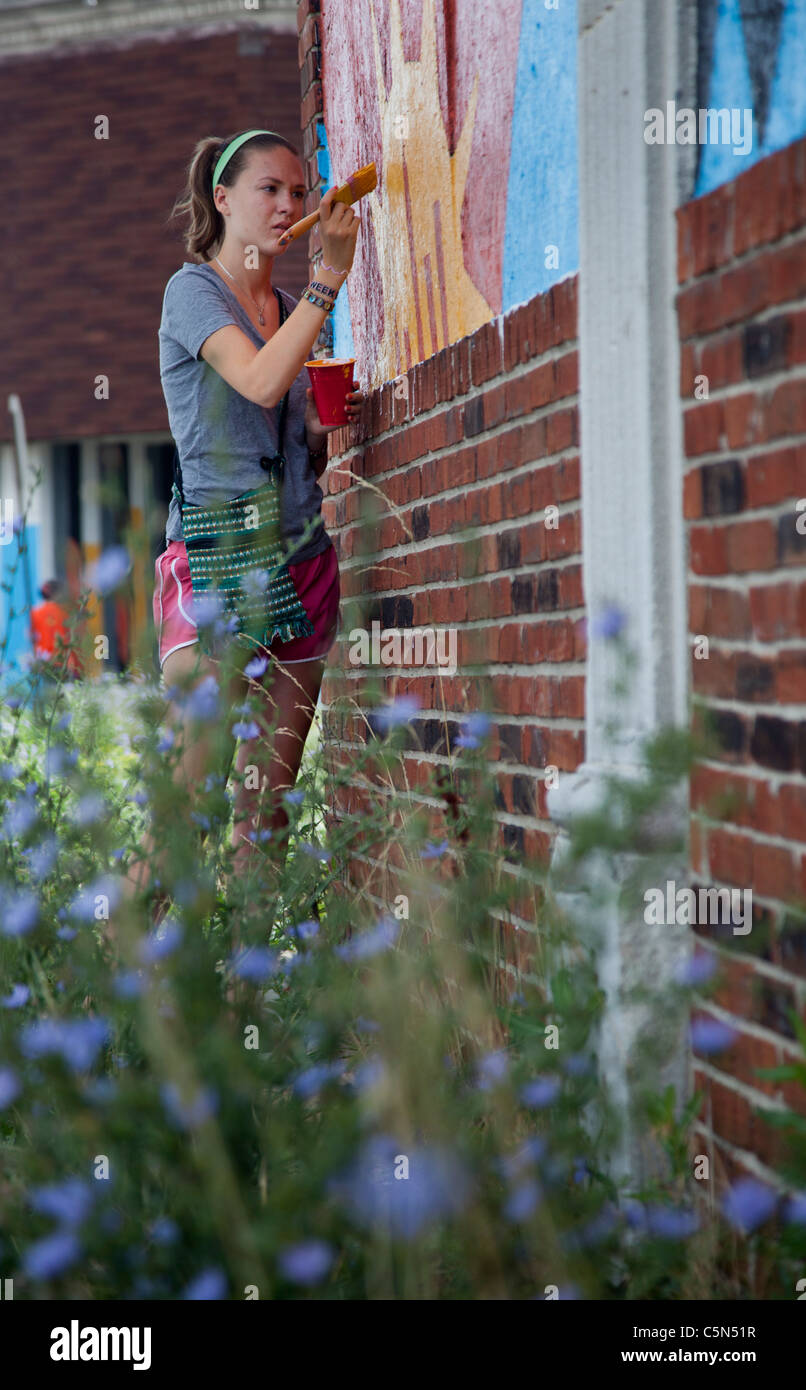 Detroit, Michigan - High school volunteers paint on an empty building. They are working through the Summer in the City program. Stock Photo