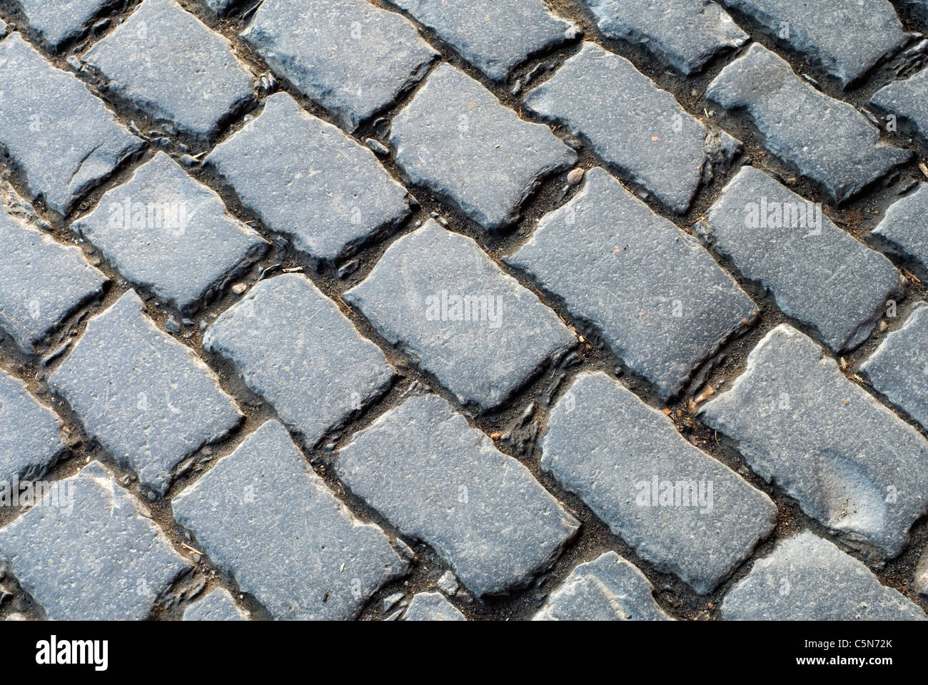 High angle view of old cobblestone street on diagonal. Original setts, commonly called Belgian Block pavers or cobblestones, Portland, Oregon Stock Photo