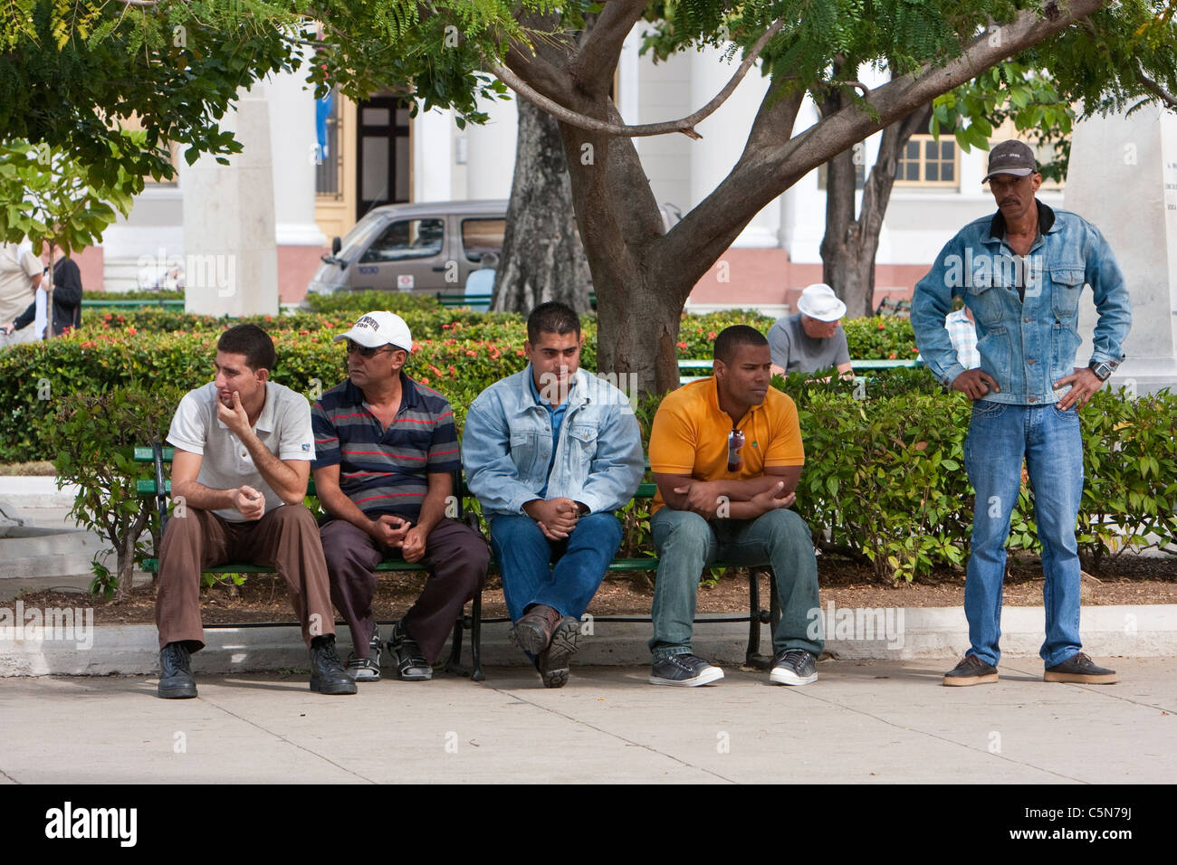Cuba, Cienfuegos. Five Men Resting in the park, the Parque Marti. Stock Photo